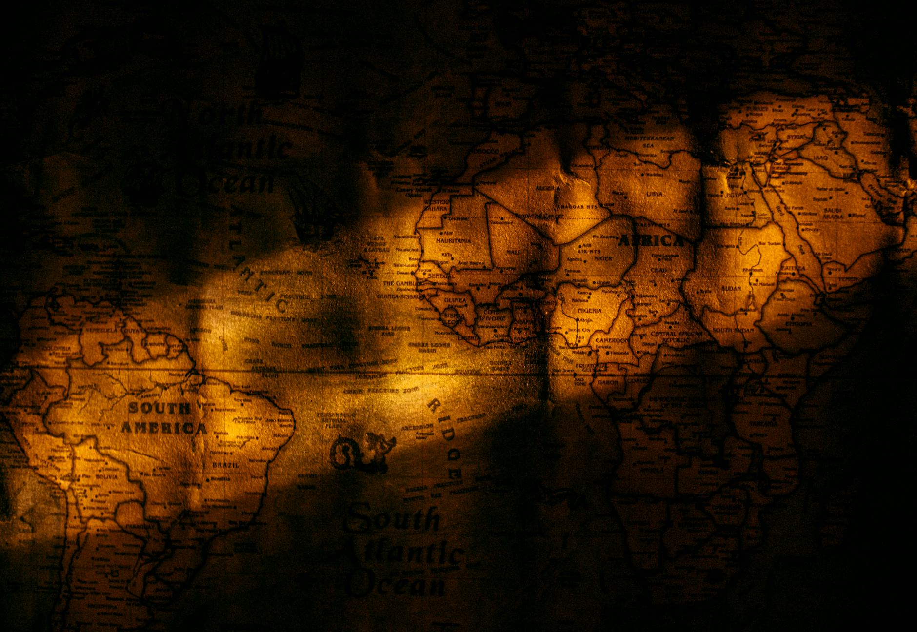 Stara mapa świata w dramatycznym świetle, symbol globalnej polityki