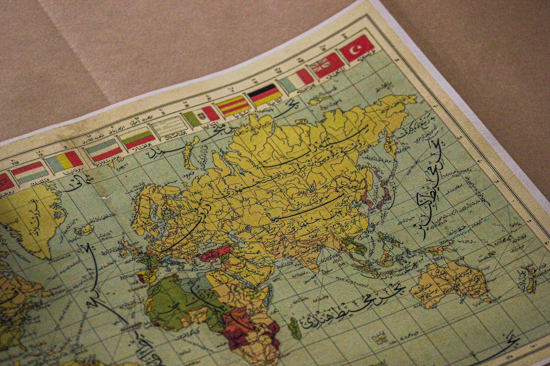 Stara mapa świata z arabskimi napisami i flagami różnych państw